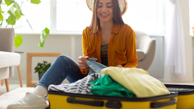 Woman preparing luggage for travel