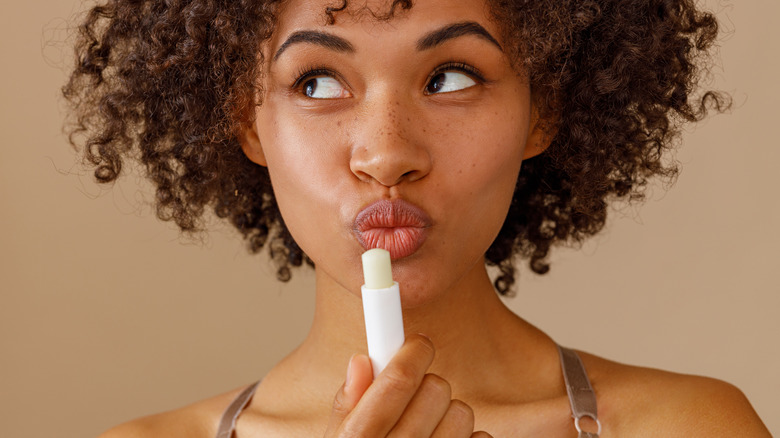 Happy woman with lip balm