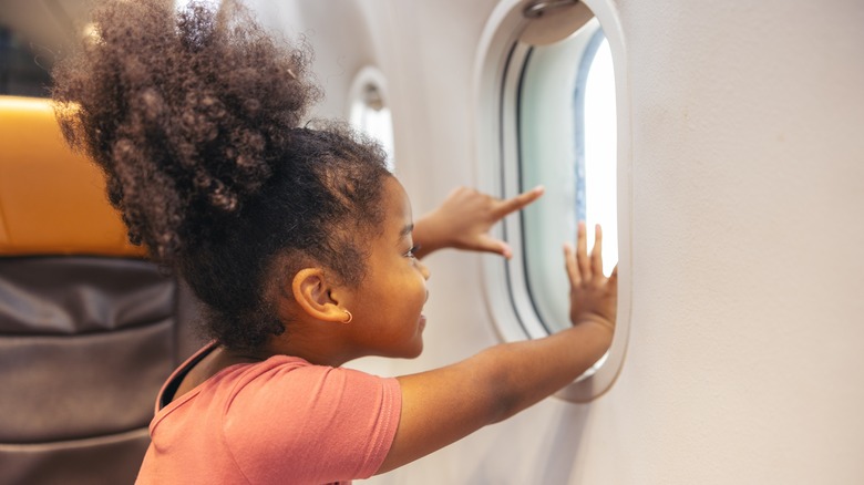 Child looking out the window on an airplane