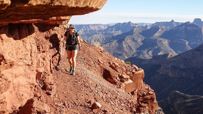 Hiker on trail on cliff edge