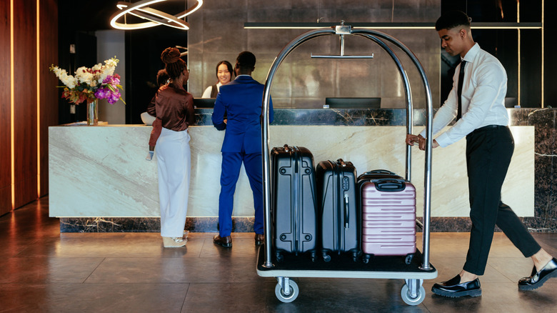 bellhop pushing luggage cart