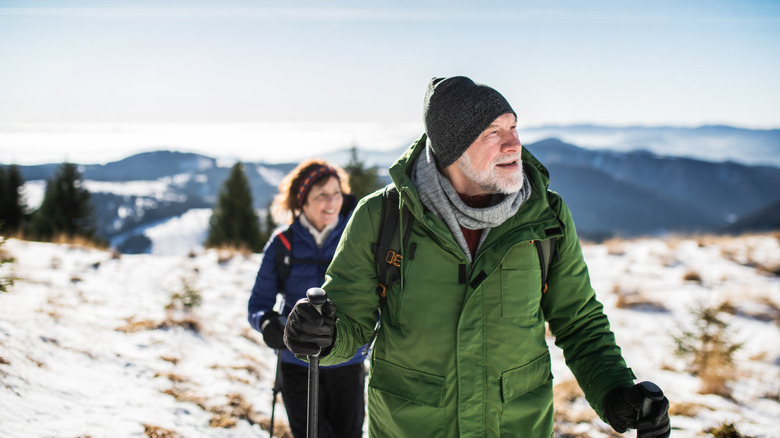 mature couple hiking in snowy mountain setting