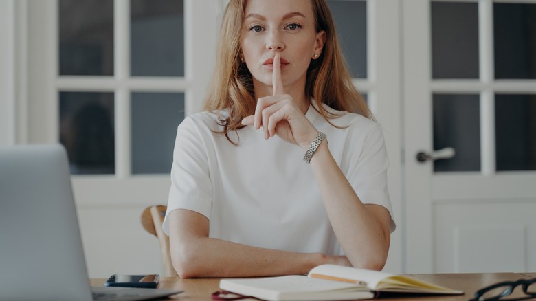 woman working holding up finger