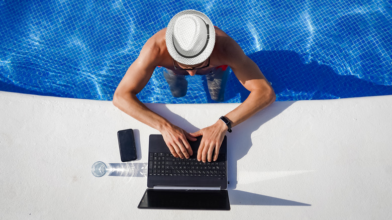man working remotely from pool