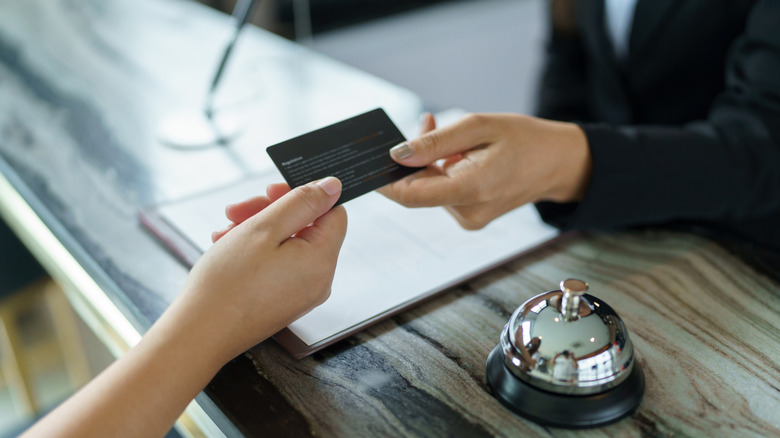 A hotel receptionist giving a card to the guest