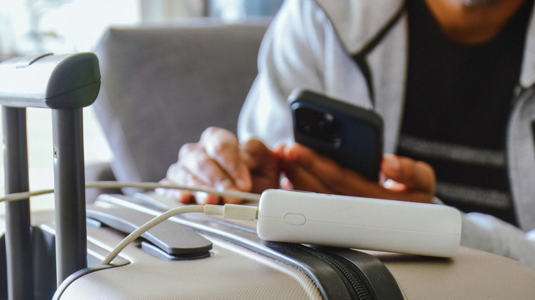 A portable charger rests on a suitcase.