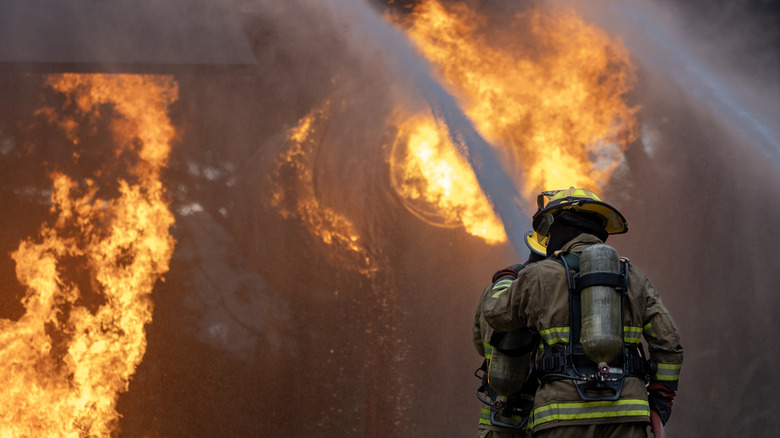 A firefighter putting out an airplane fire.