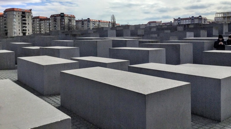 concrete rectangles at Berlin Holocaust Memorial with buildings in background