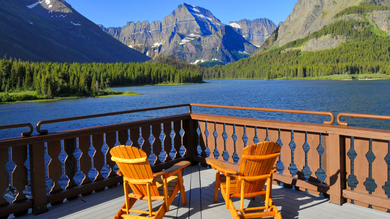 chairs on a deck overlooking an alpine lake at the Many Glacier Hotel