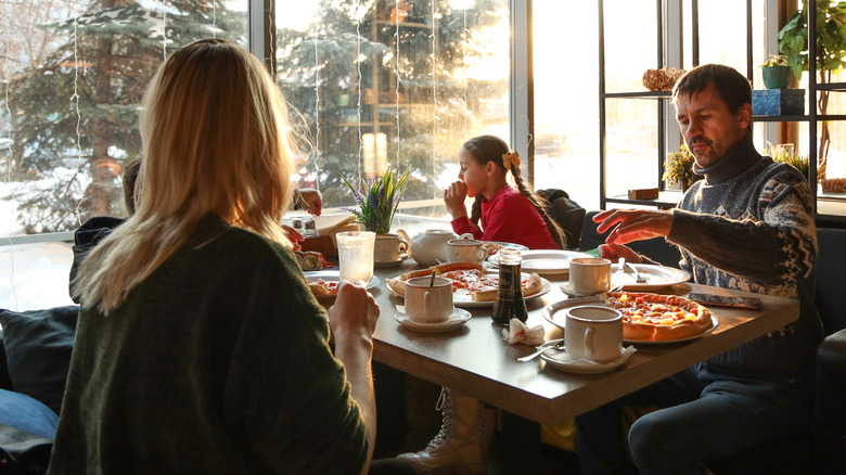 A family eats pizza in a cafe