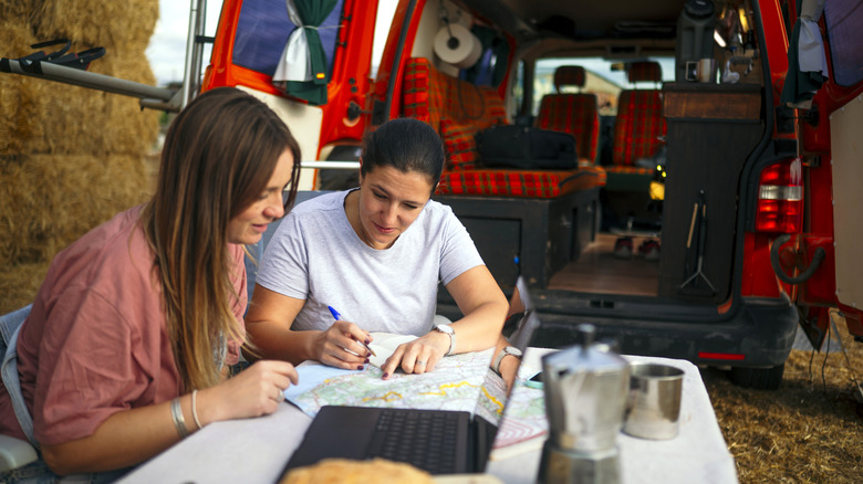 Couple planning their road trip route in a campervan