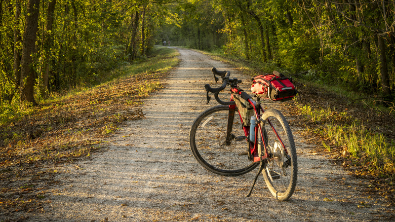 bike resting on stand on gravel Katy Trail in lush forest in Missouri