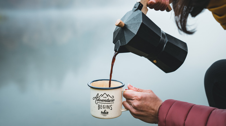 A person pouring coffee outdoors