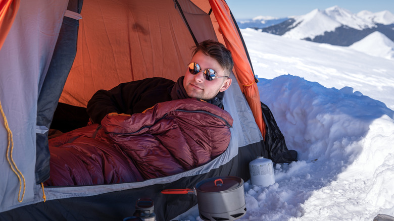 man in tent in snow