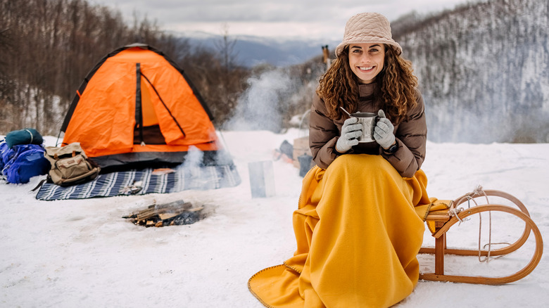 woman smiling at snowy campsite