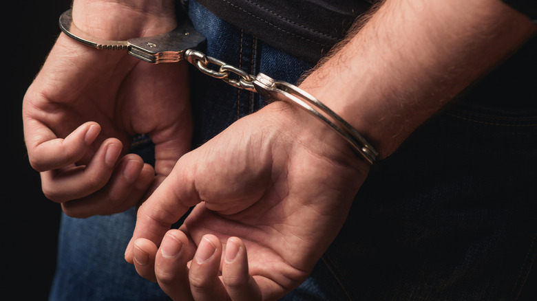 Close-up on hands in handcuffs.