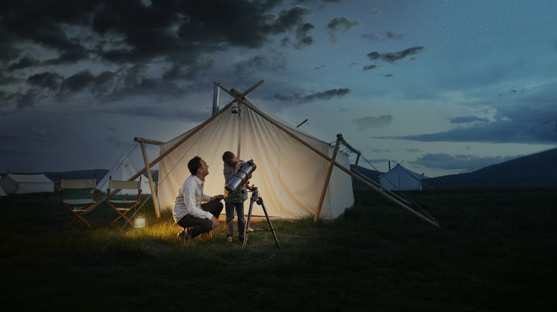 A son and father looking at sky glamping