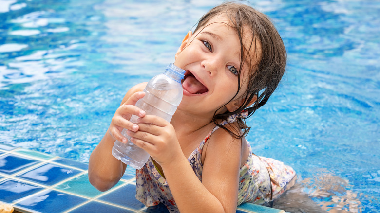 child drinking water in a pool