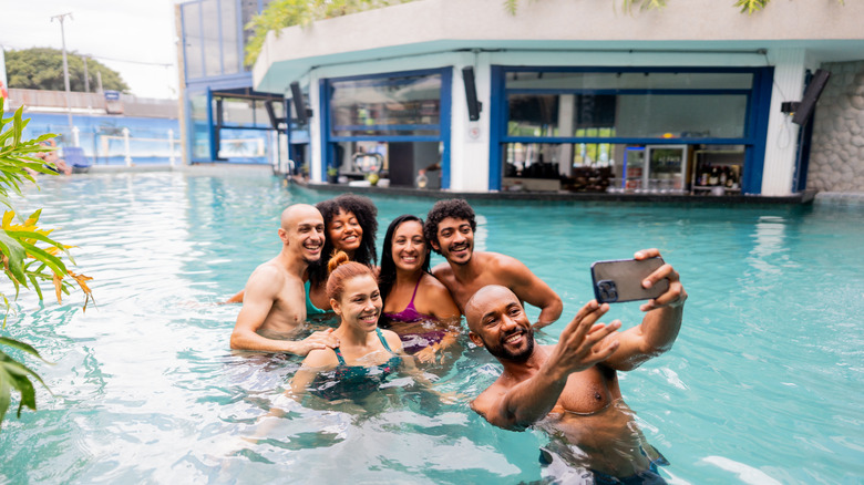 group of friends taking picture in resort pool