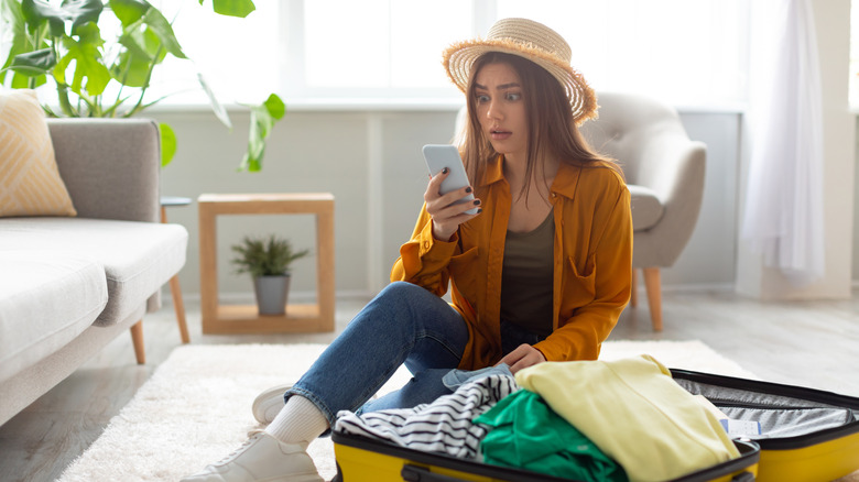 woman staring at smartphone screen in terror