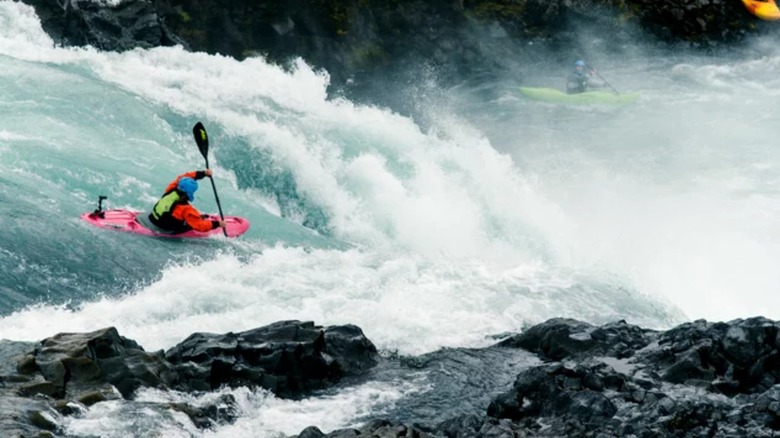 man kayaking through rapids