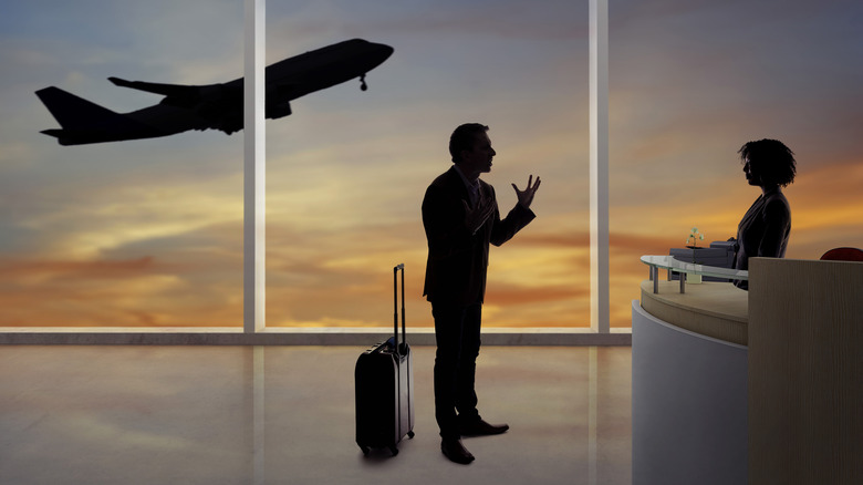 Frustrated airline passenger talking with someone at a desk