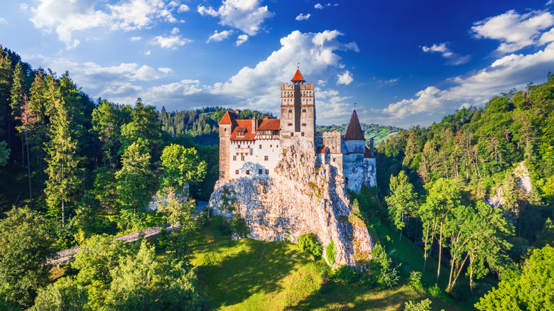 Bran Castle in Romania seen from a distance and surrounded by forest