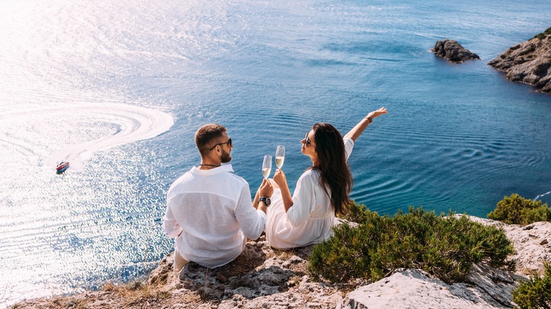 couple drinking champagne on cliff