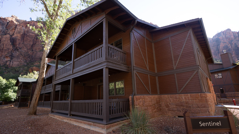 the rustic Sentinel building at the Zion Lodge with sandstone mountains in the background in Zion National Park, Utah