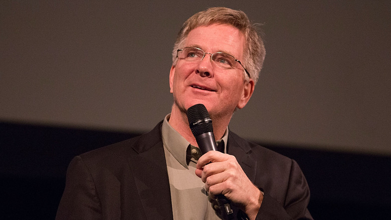 Rick Steves holding microphone wistfully