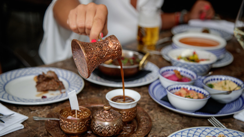 A woman pours some Turkish coffee