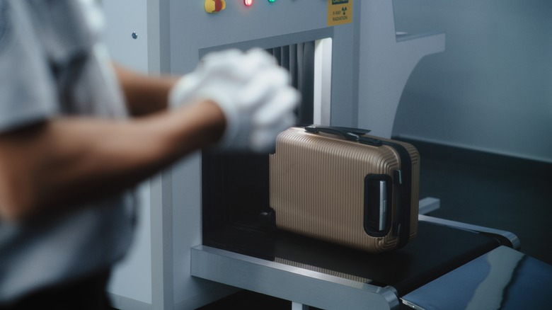 Airport security guard allows a bag to enter X-ray
