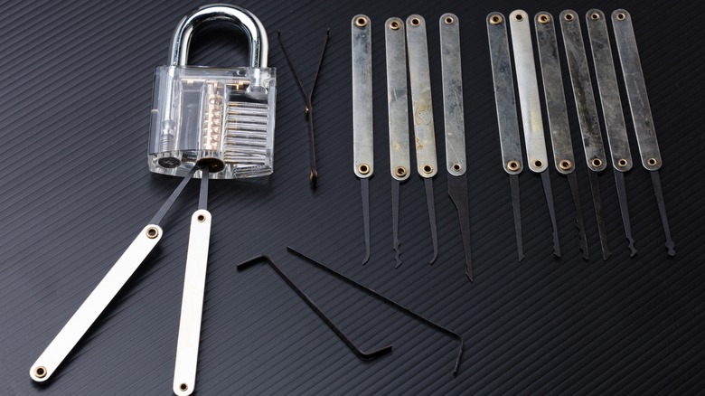 A collection of lock picks lies on a black background