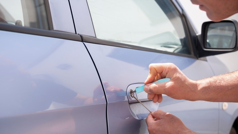 A locksmith attempts to open a car door