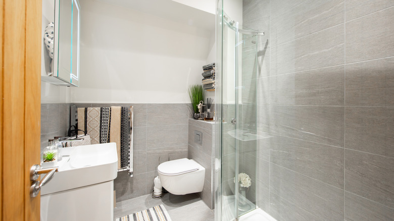 General view of the interior of a bathroom with standing shower stall, toilet, and sink