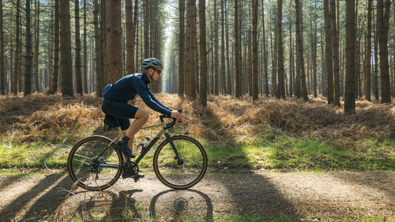 A man cycles down a bikepath in the morning sun