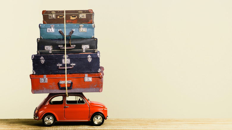 Suitcases piled on car