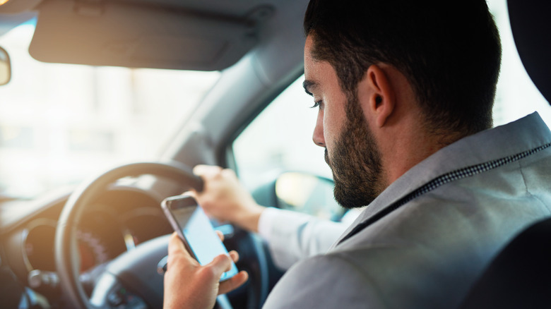 Aman using his phone while driving