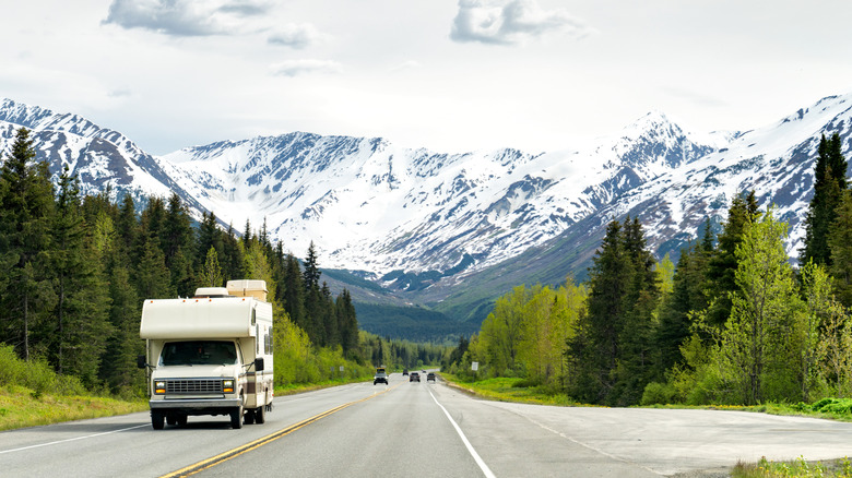 RV driving on road backed by mountains