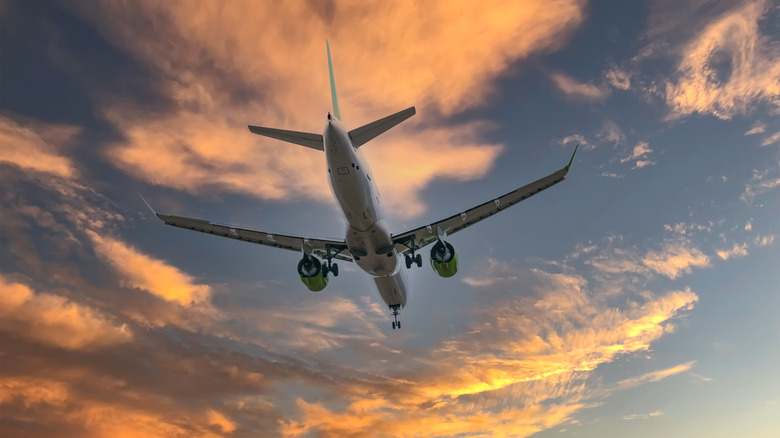 Plane flying in colorful clouds