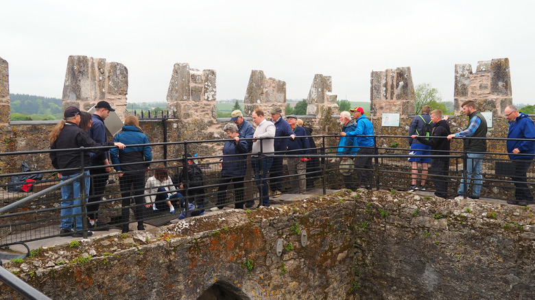tourists lined up on castle rampart