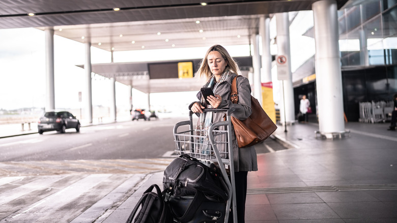 Woman booking Uber from airport