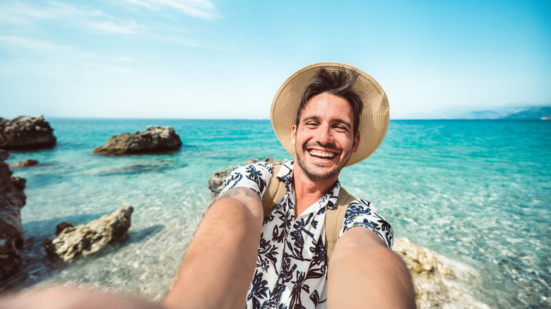 Happy man taking selfie with smart mobile phone outside