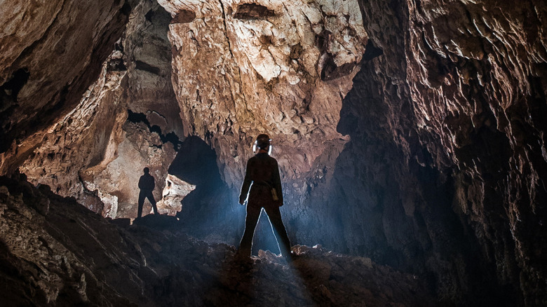 Cavers exploring a dark cave