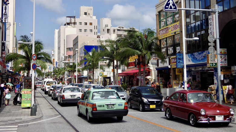 Kokusai-dori shopping street palm trees cars