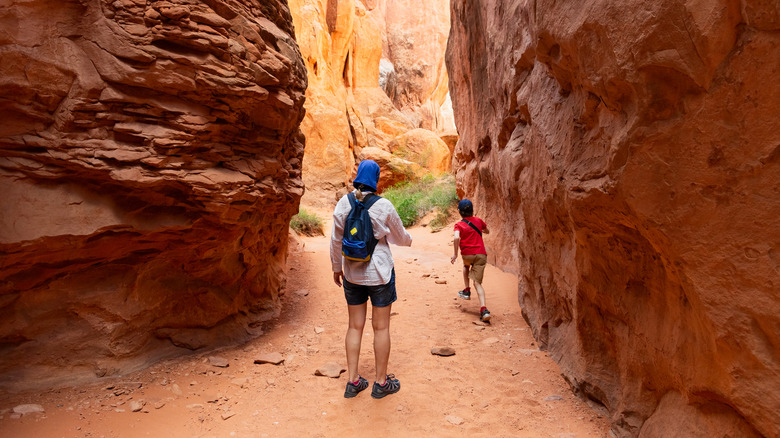 two hikers walking through the canyon at Arches National Park, Utah