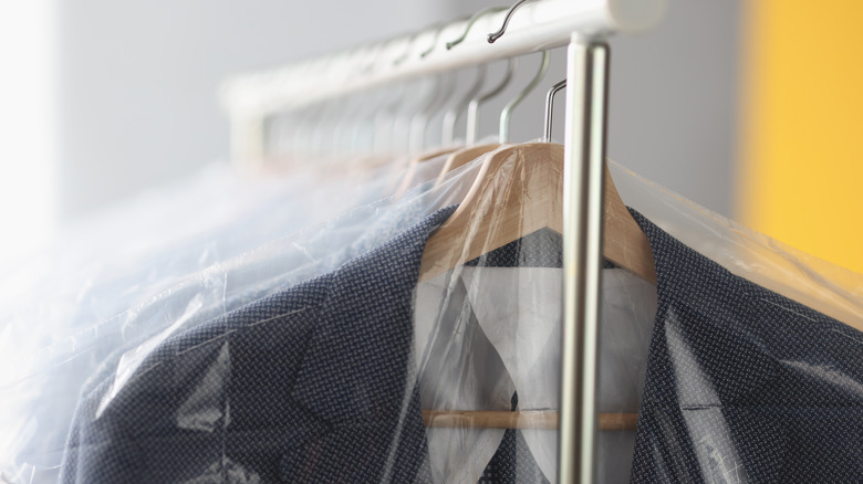 Close up of clothing hanging on a rack in garment bags