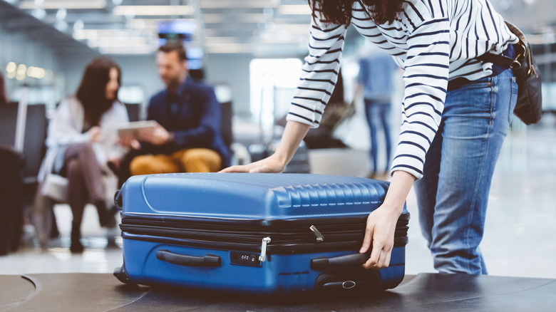 Woman getting suitcase in airport