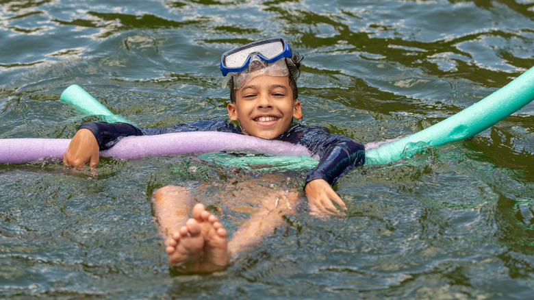 Boy with pool noodles