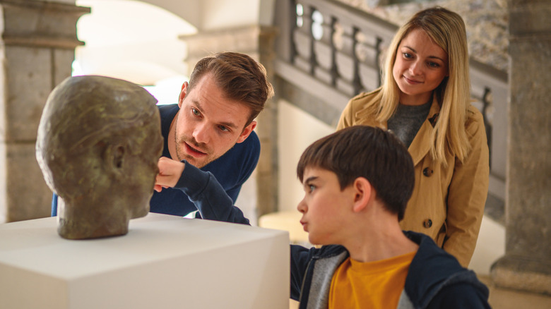 Family looking at museum sculpture